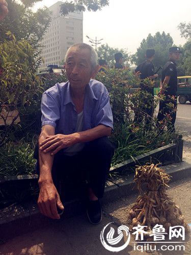 在聊城三中门口等待的戴仁喜老人
